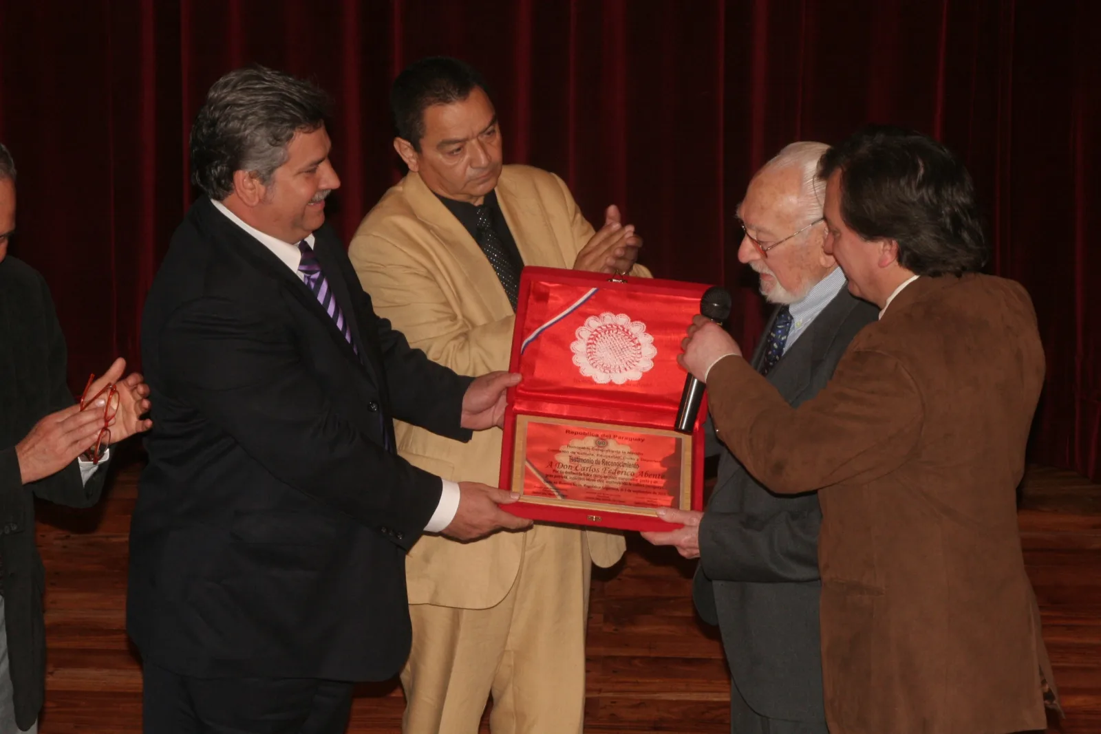 Isidro 10 Abente (va) El senador Orlando Fiorotto haciendo entrega de la plaqueta recordatoria. En el centro, Isidro Méndez Chávez, Presidente de Casa Paraguaya (foto Oscar)