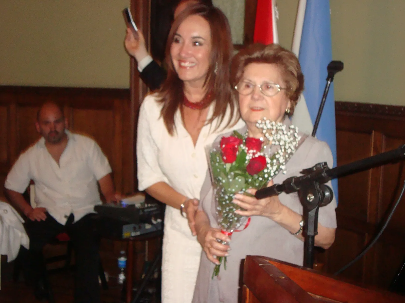 Cynthia Filártiga, Primer Secretaria de la Embajada del Paraguay, entregando un ramo de flores a Élida Vallejos, viuda del poeta