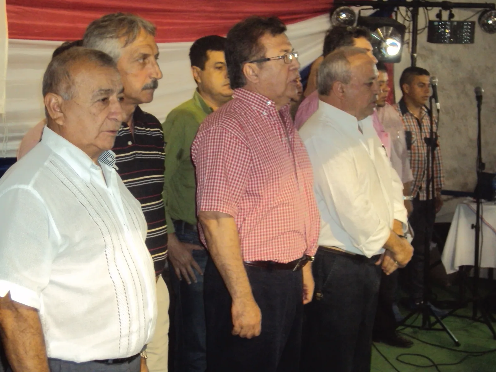 En el escenario entonando los himnos nacionales: de Izq. a derecha Antonio Aranda, Miguel A. Bampini, Nicanor Duarte Frutos y Salomón Ramírez Santacruz