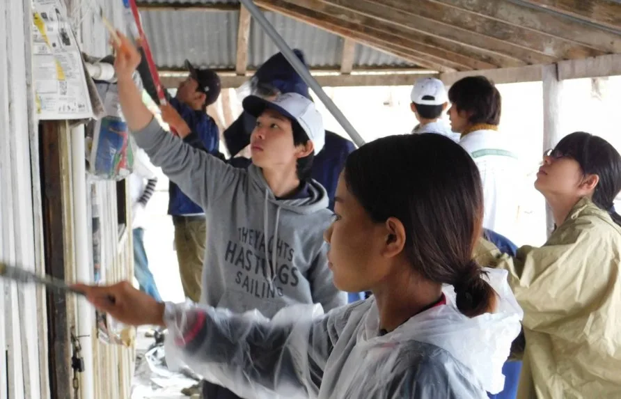 Una niña indígena y los japoneses pintan la escuela de Puerto Diana. En los momentos libres practicaron dinámicas grupales. La visita fue muy valorada por los nativos. / ABC Color