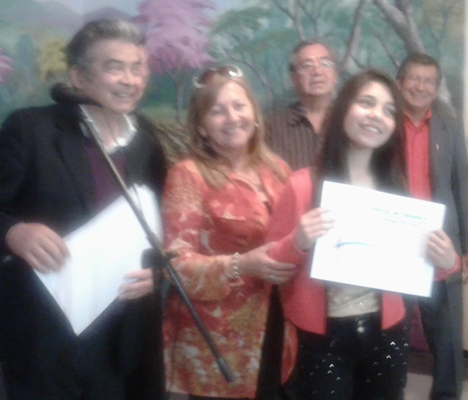 Aylim Paredes, recibiendo el diploma que lo acredita como ganadora solista de canto menor. Atrás, los otros integrantes del jurado